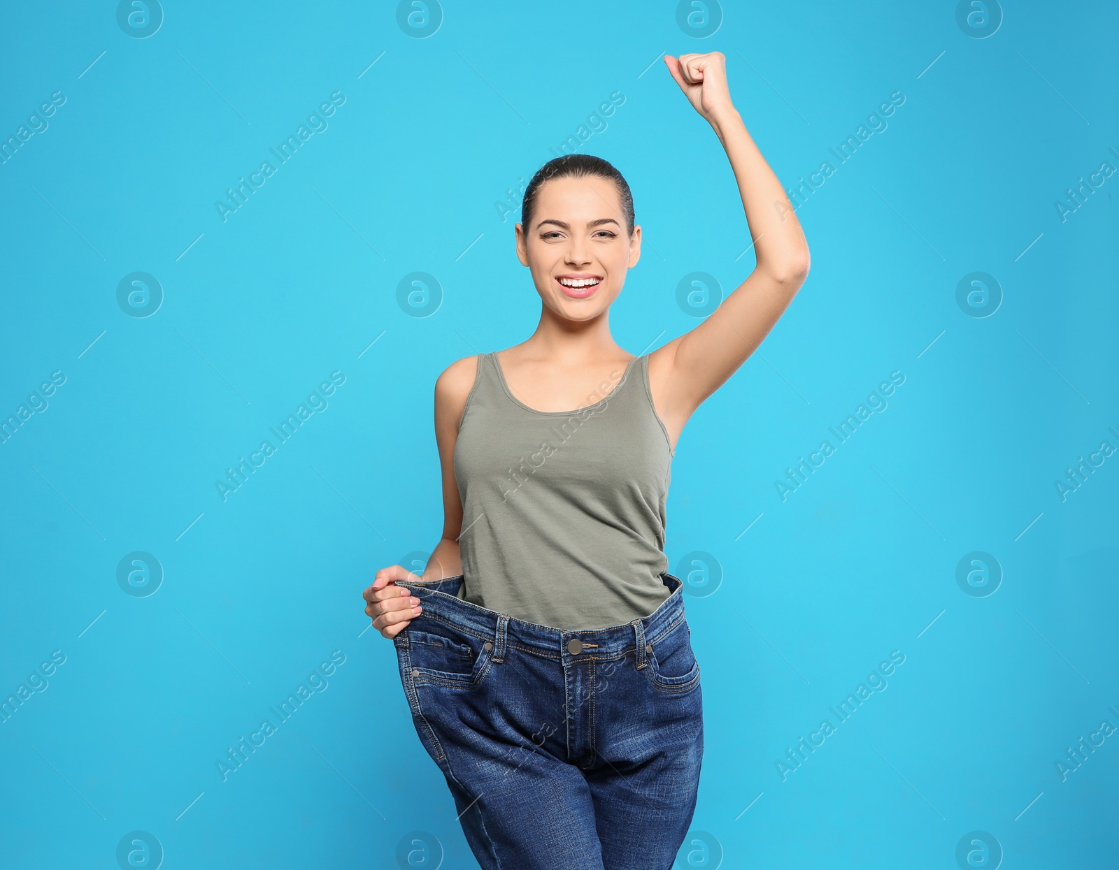 Photo of Slim woman in oversized jeans on color background. Weight loss