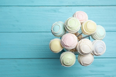 Photo of Sweet cake pops on light blue wooden background, top view. Space for text