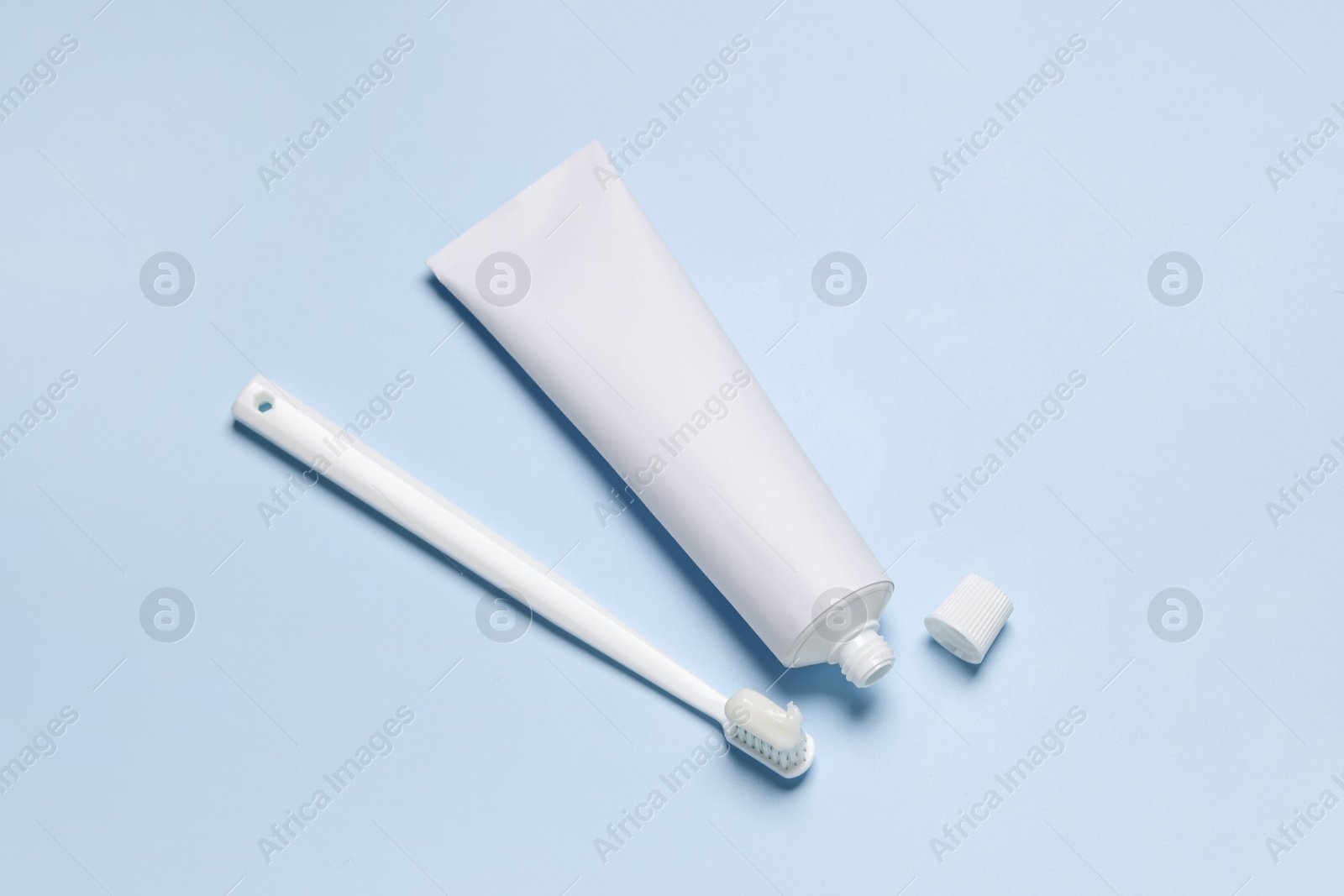 Photo of Plastic toothbrush and paste on light background, flat lay