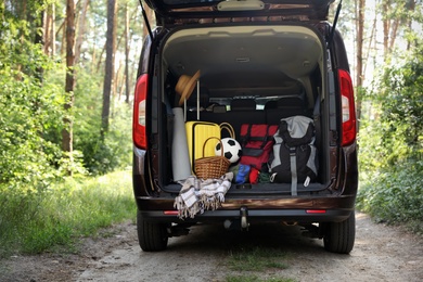 Photo of Van with camping equipment in trunk outdoors