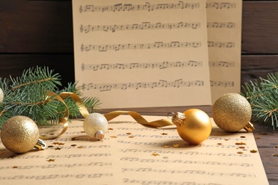 Photo of Composition with Christmas decorations and music sheets on table