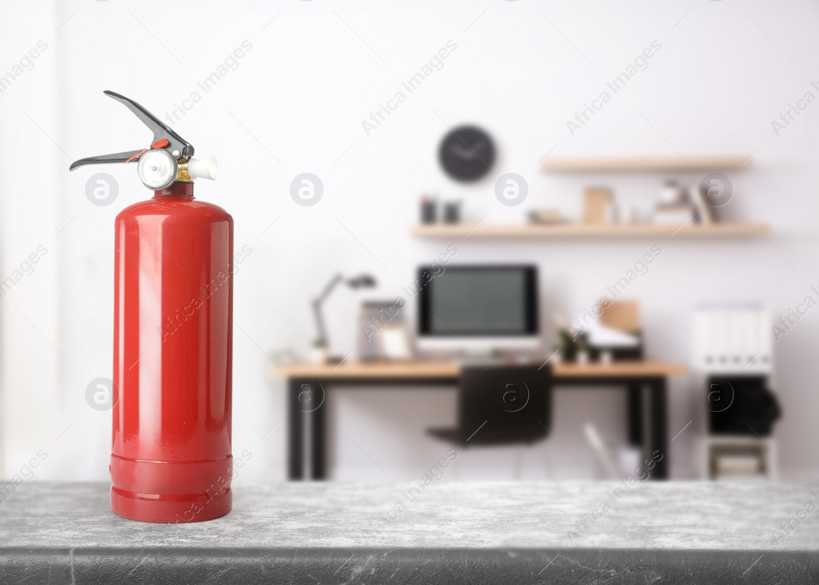 Image of Fire extinguisher on stone table in office. Space for text