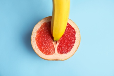 Fresh grapefruit and banana on blue background, top view. Sex concept