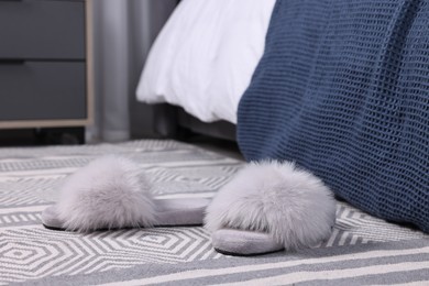 Photo of Grey soft slippers on carpet indoors, closeup