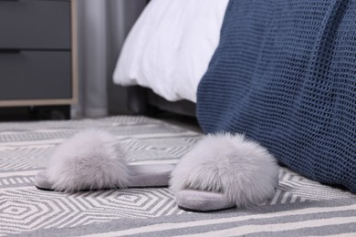 Grey soft slippers on carpet indoors, closeup