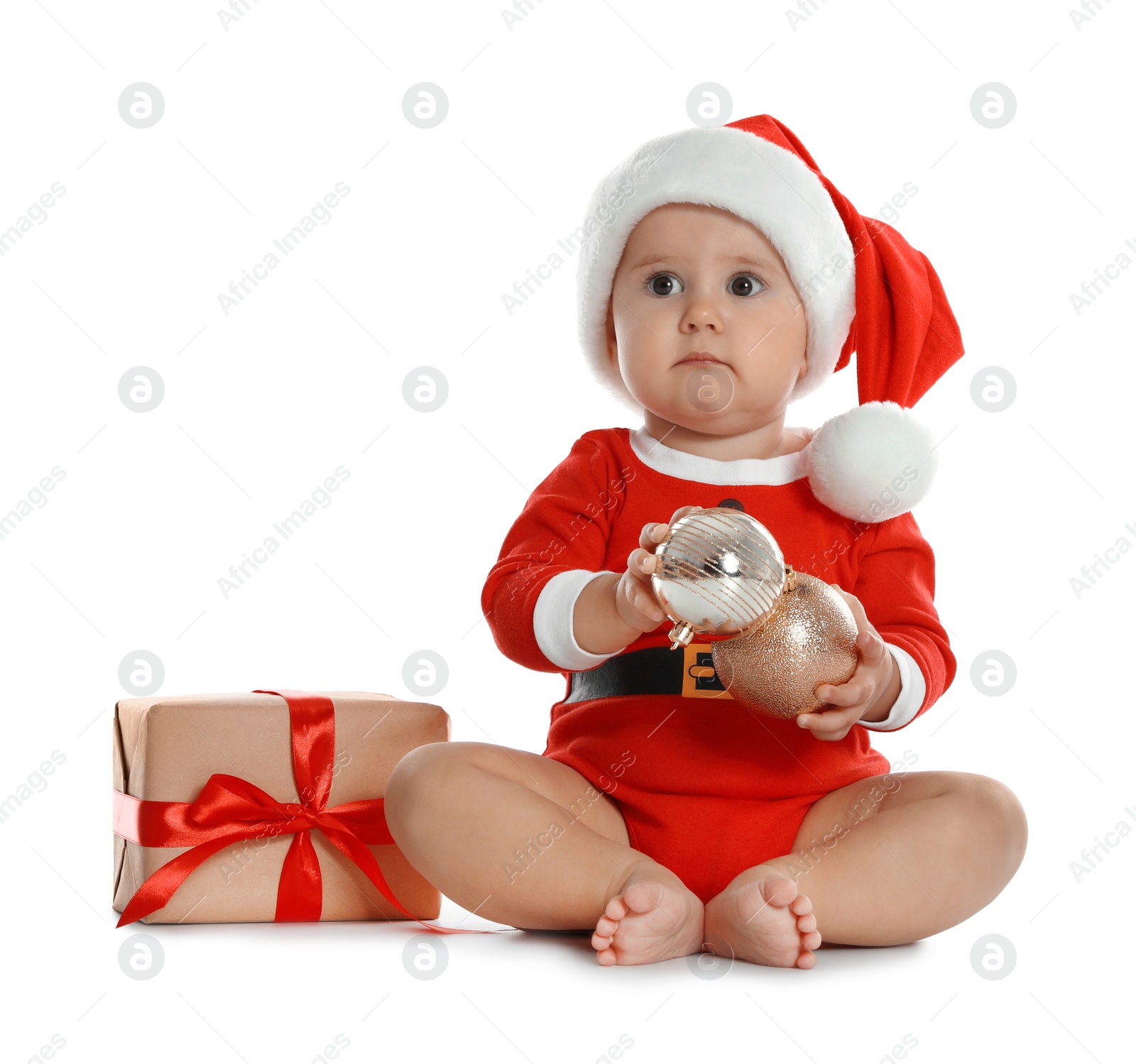 Photo of Festively dressed little baby with Christmas gift on white background