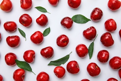 Photo of Sweet red cherries and leaves on white background