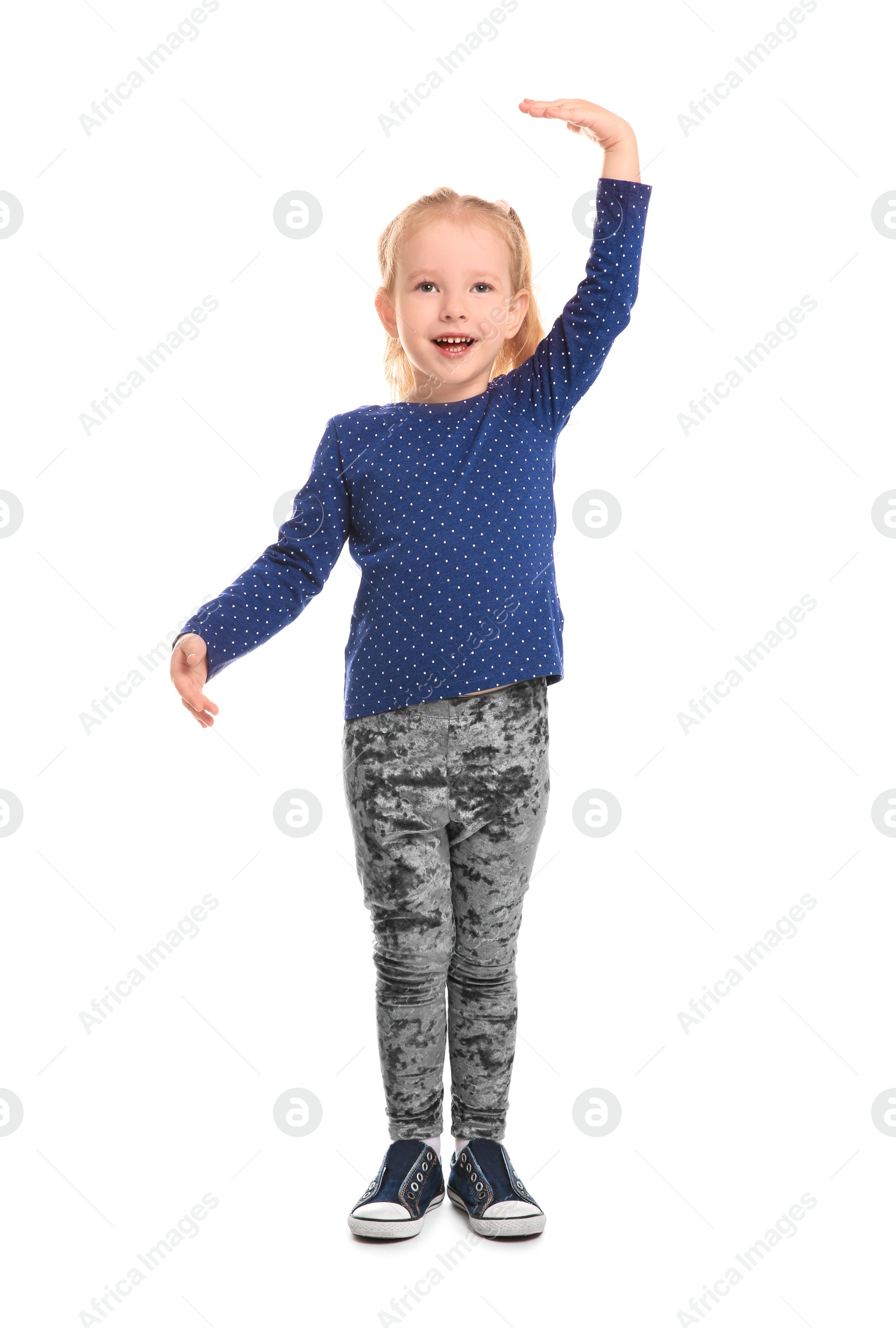 Photo of Little girl measuring her height on white background