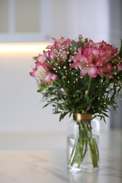 Photo of Vase with beautiful alstroemeria flowers on table in kitchen. Interior design