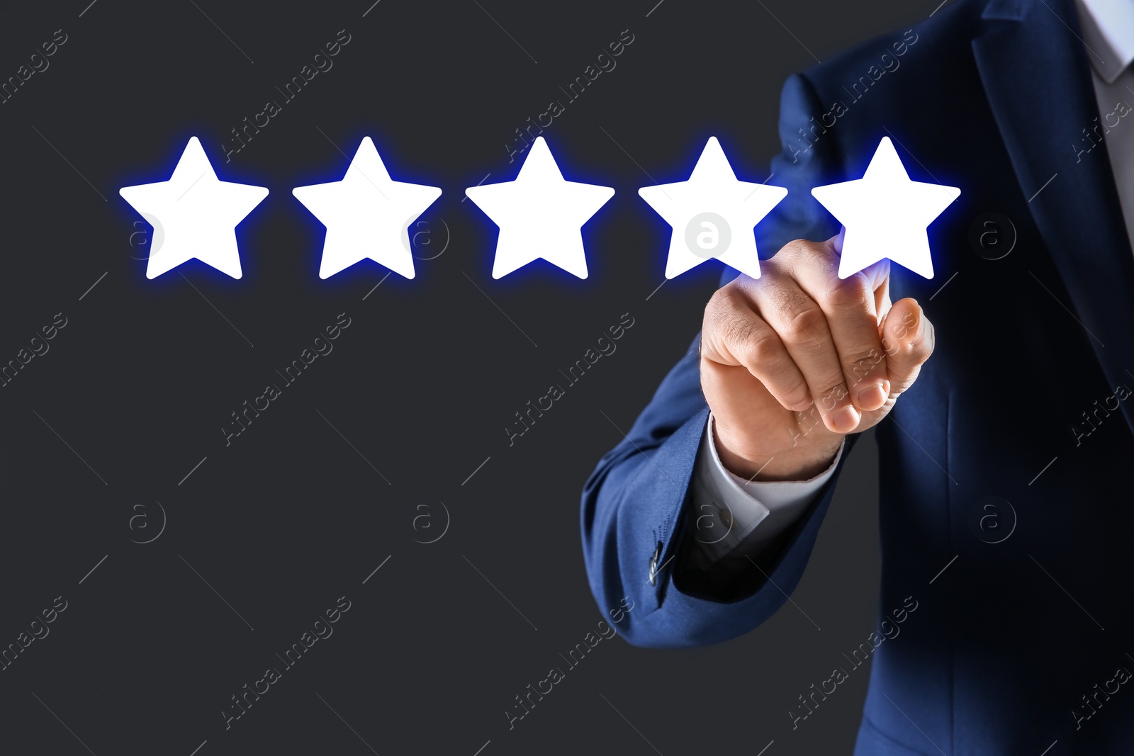 Image of Man pointing at icons of five stars on dark grey background, closeup. Quality rating