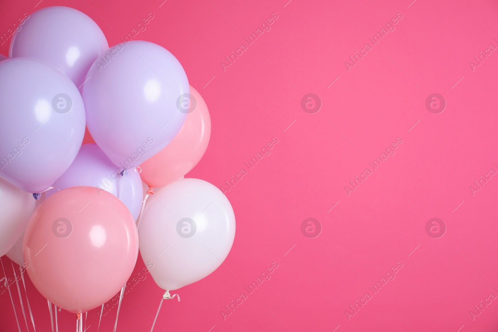 Photo of Colorful party balloons on pink background. Space for text