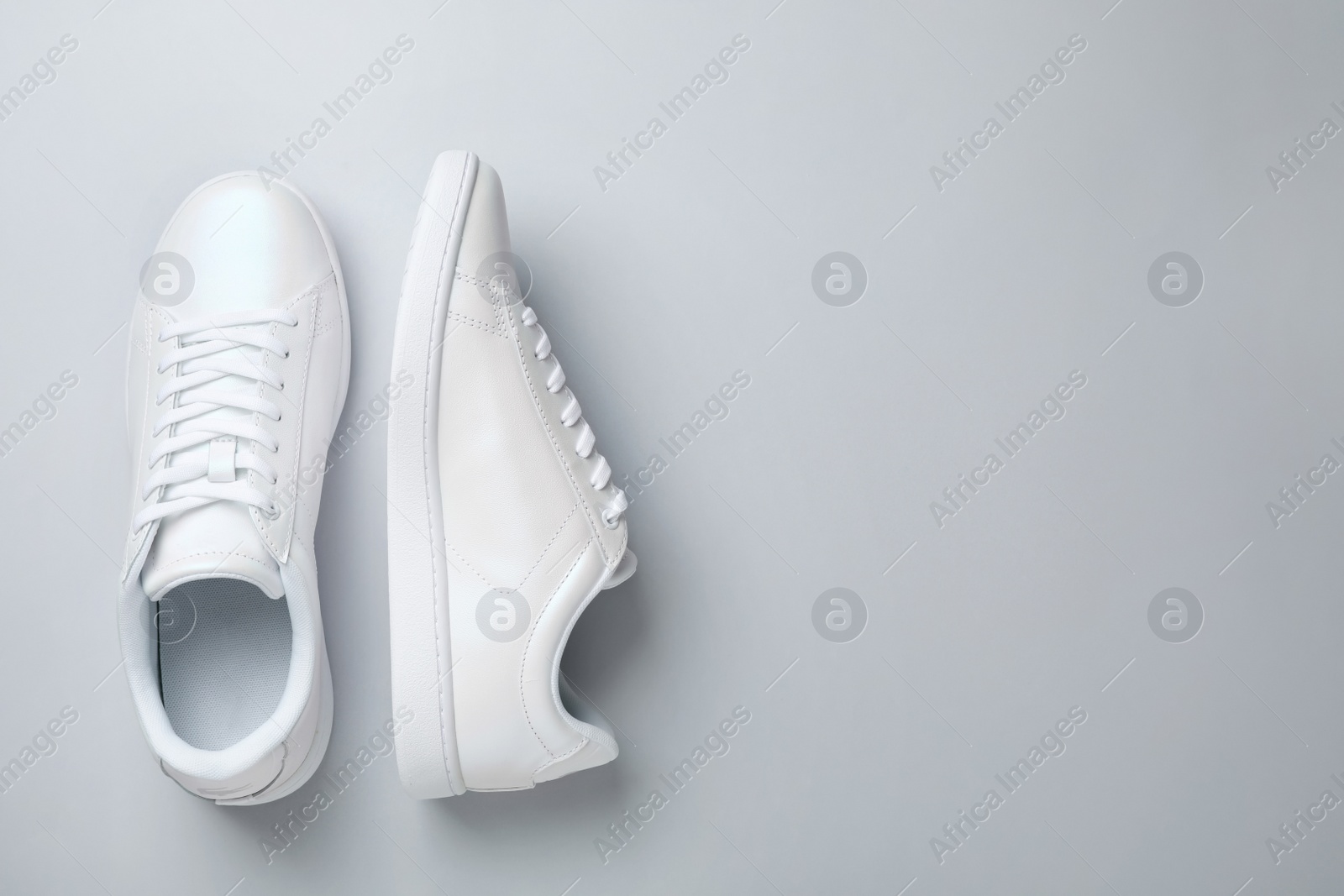 Photo of Pair of trendy sneakers on light background, flat lay. Space for text