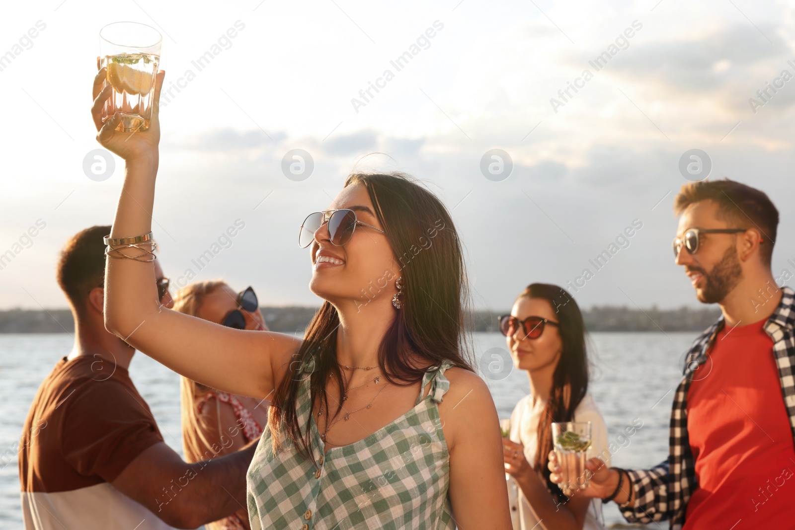 Photo of Woman with friends having fun near river at summer party