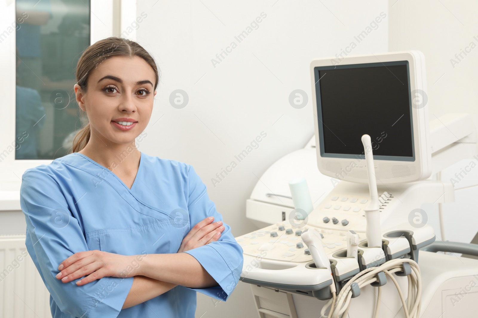 Photo of Professional sonographer near modern ultrasound machine in clinic