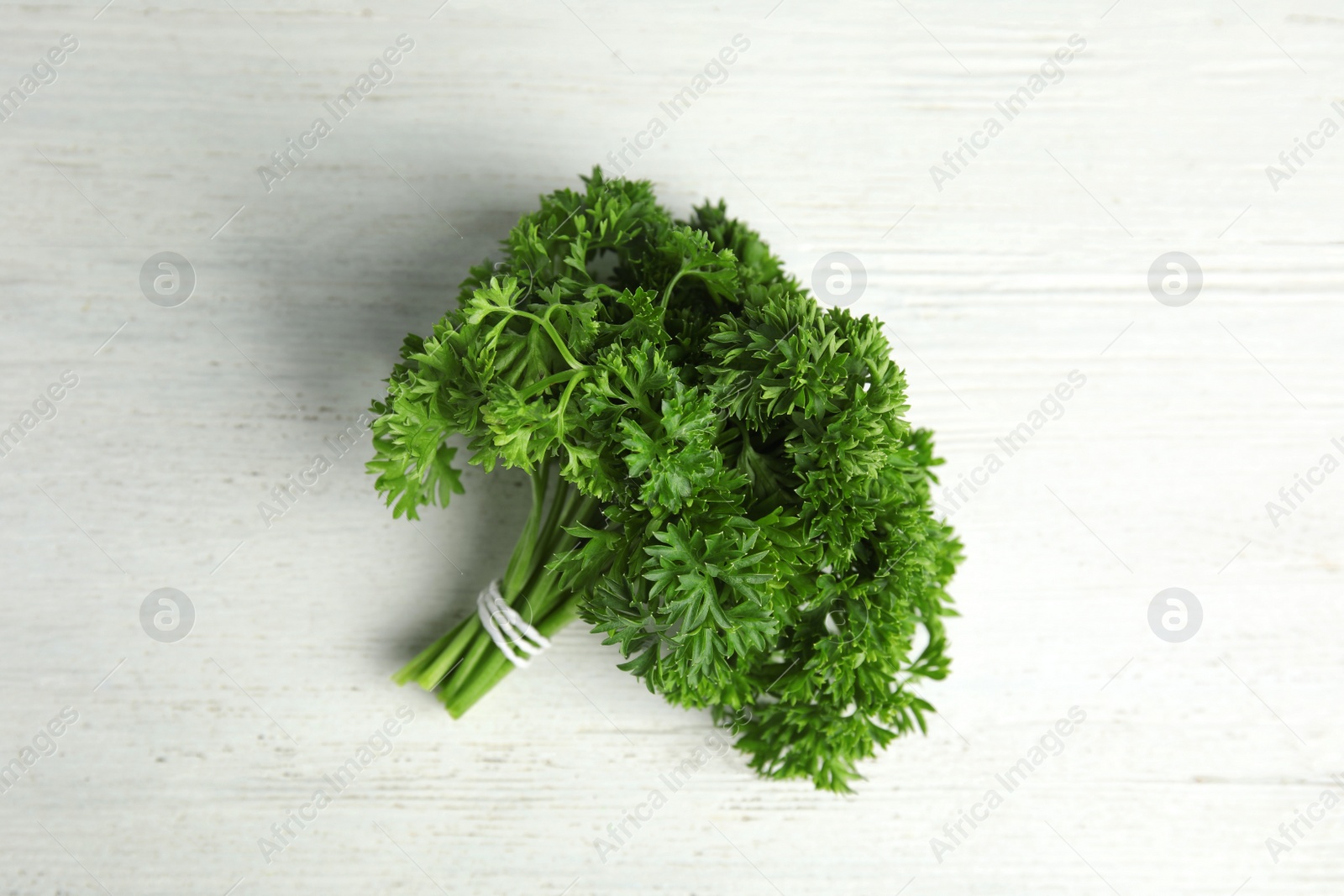 Photo of Bunch of fresh green parsley on wooden background, top view