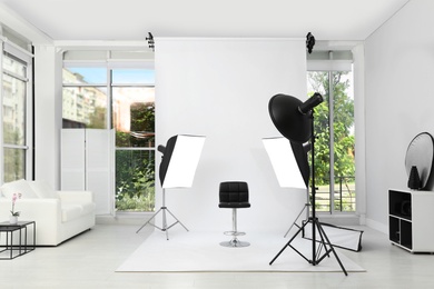 Photo of Interior of modern photo studio with chair and professional equipment