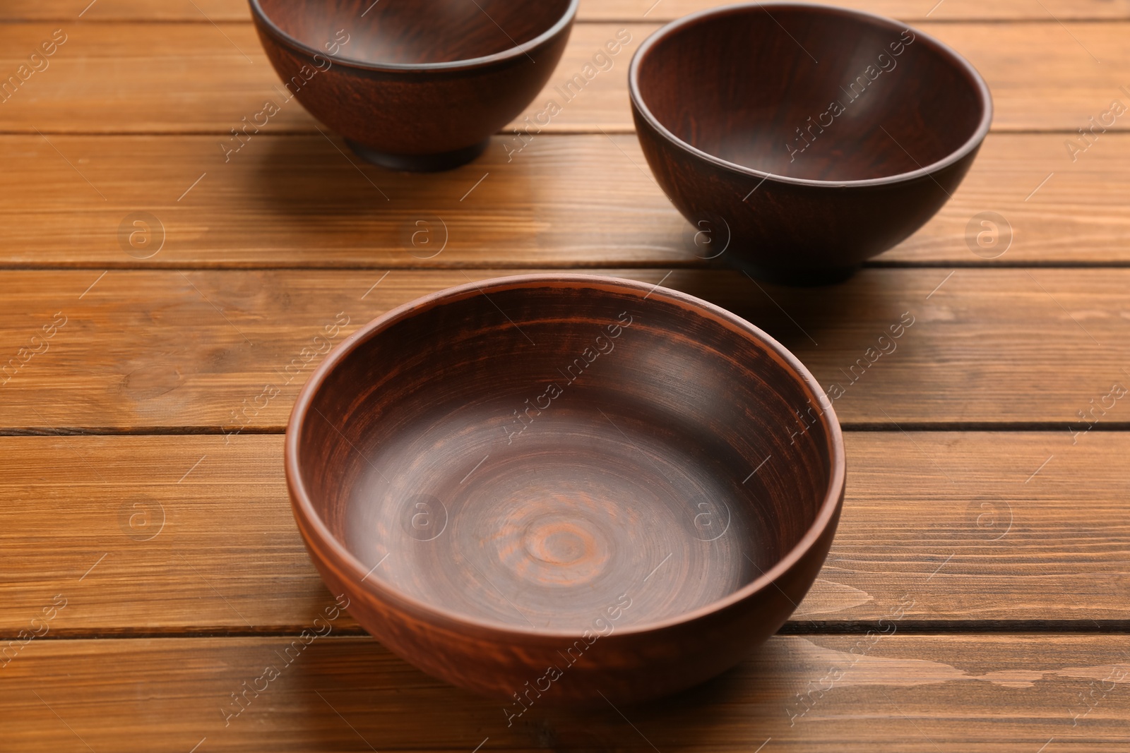 Photo of Beautiful empty clay bowls on wooden table