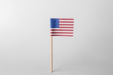 Photo of Small paper flag of USA on light background. Space for text