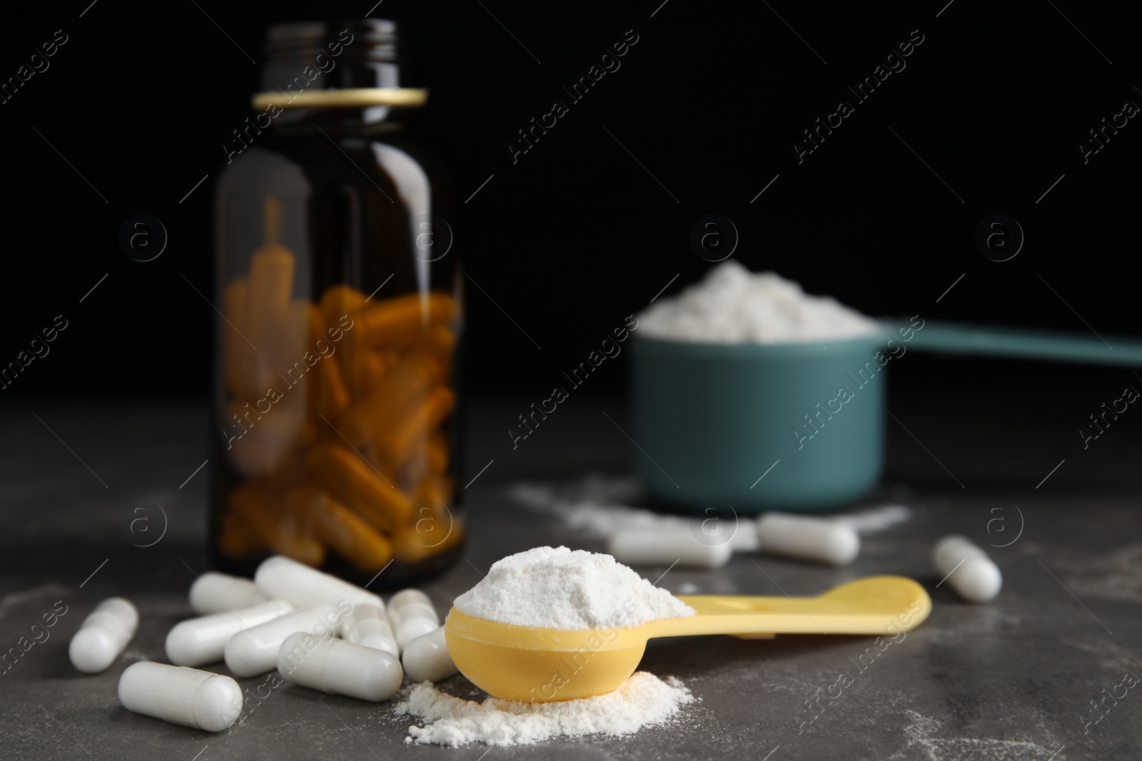 Photo of Amino acid pills and powder on grey table