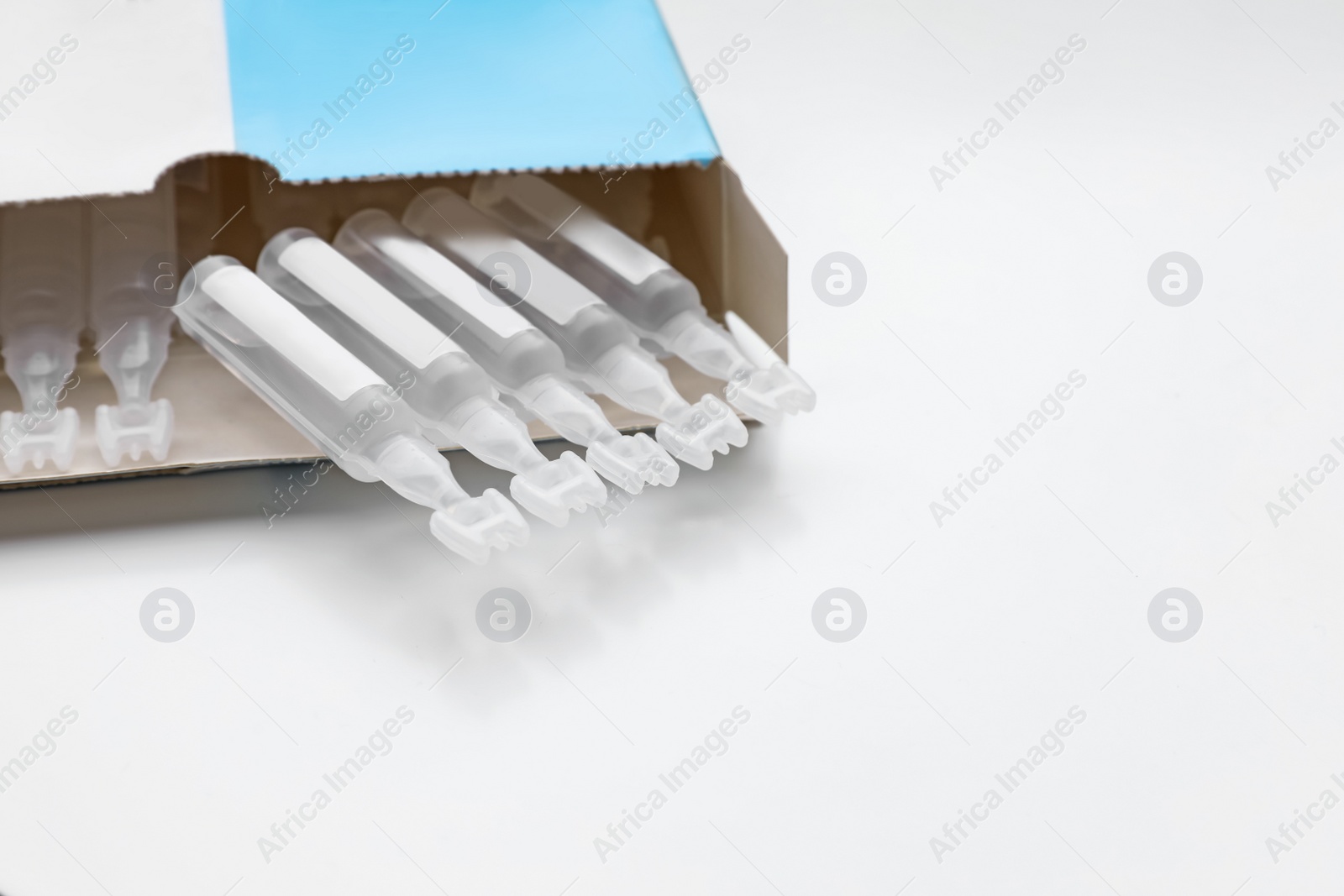 Photo of Package with single dose ampoules of sterile isotonic sea water solution on white background. Space for text