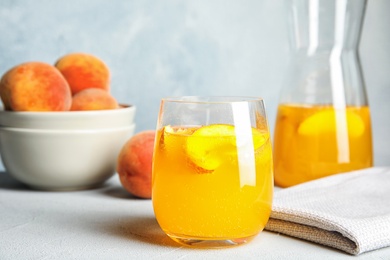 Photo of Tasty peach cocktail on table. Refreshing drink