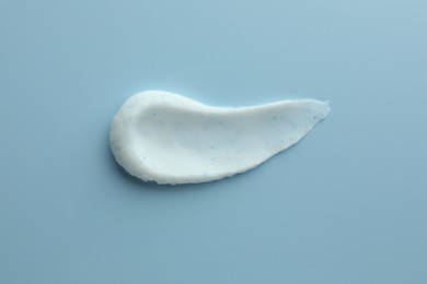 Photo of Sample of face scrub on light blue background, top view