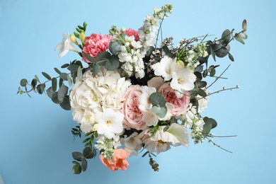 Photo of Bouquet of beautiful flowers on light blue background, top view