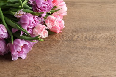 Beautiful bouquet of colorful tulip flowers on wooden table, space for text
