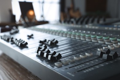 Photo of Professional mixing console on table in radio studio, closeup