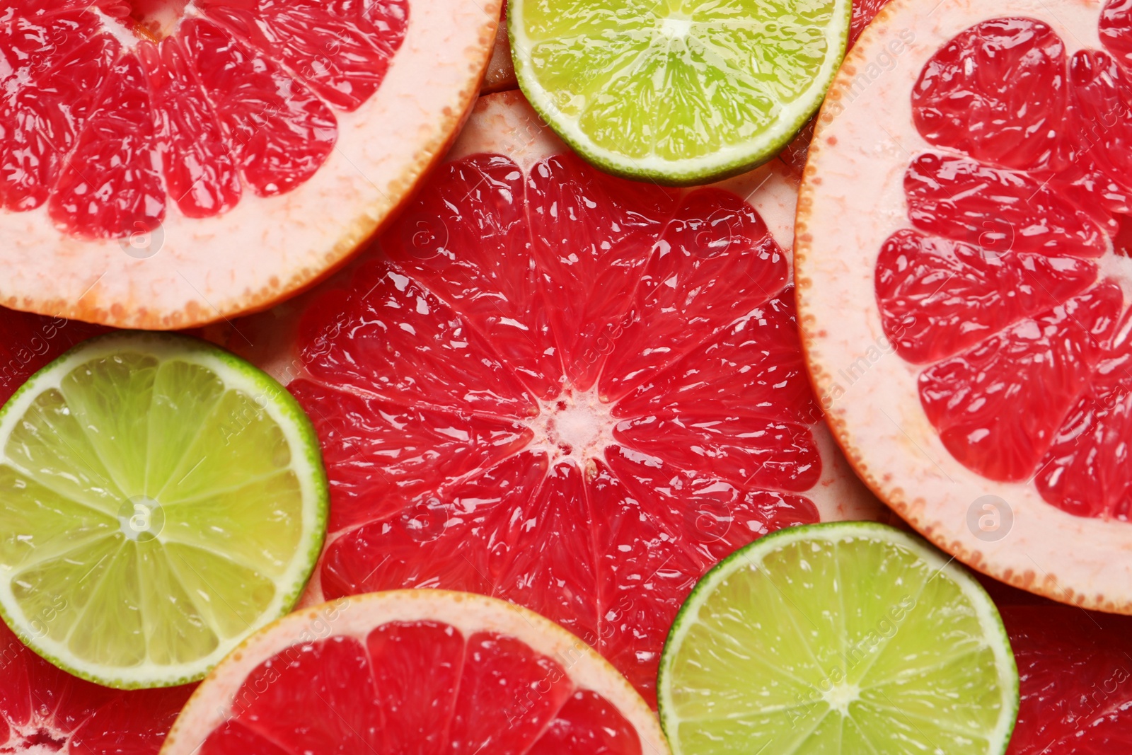 Photo of Slices of grapefruit and lime as background, top view