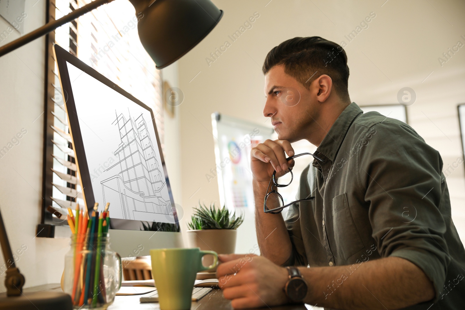 Image of Architect making project of house on computer in office