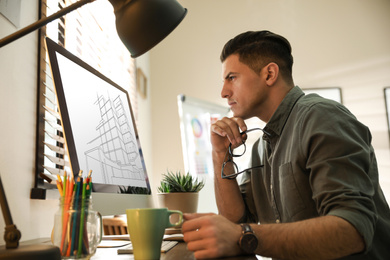 Image of Architect making project of house on computer in office