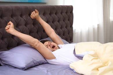 Handsome man stretching at home in morning. Bedtime