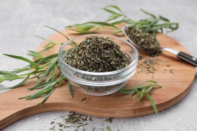 Photo of Dry and fresh tarragon on light gray textured table