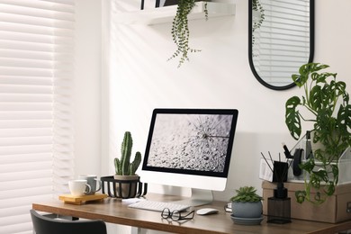 Photo of Cozy workspace with computer on wooden desk at home