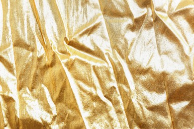 Golden shiny fabric as background, top view