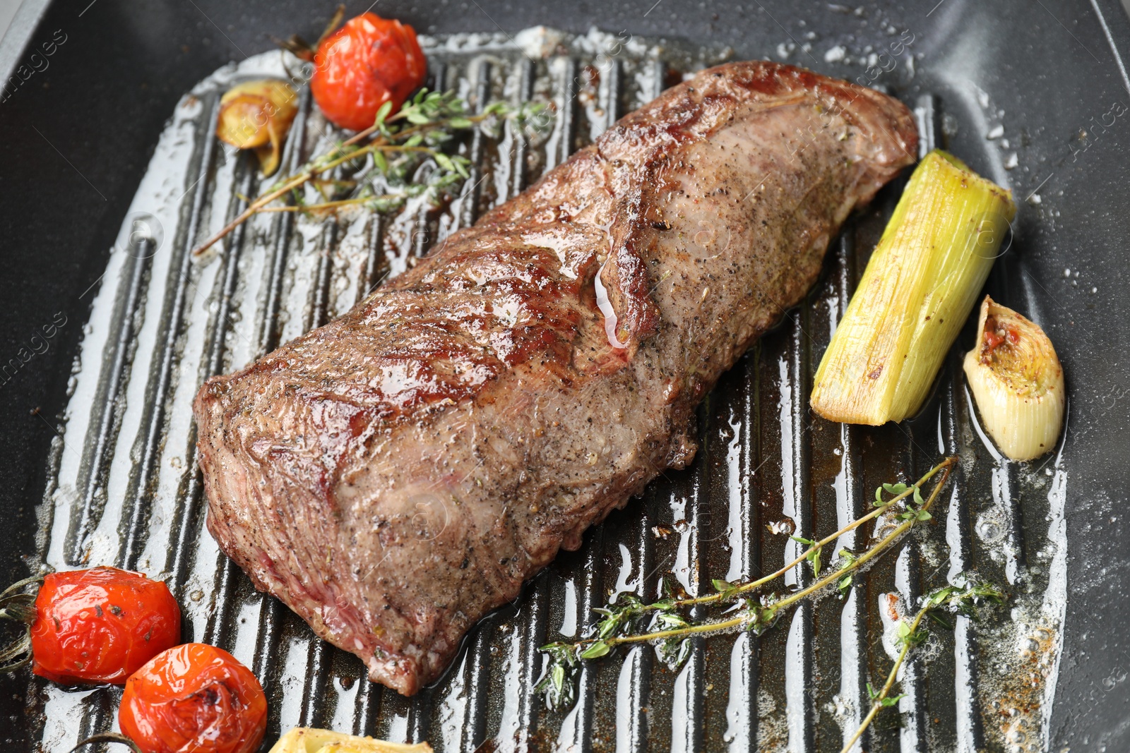 Photo of Delicious grilled beef meat and vegetables in pan, closeup