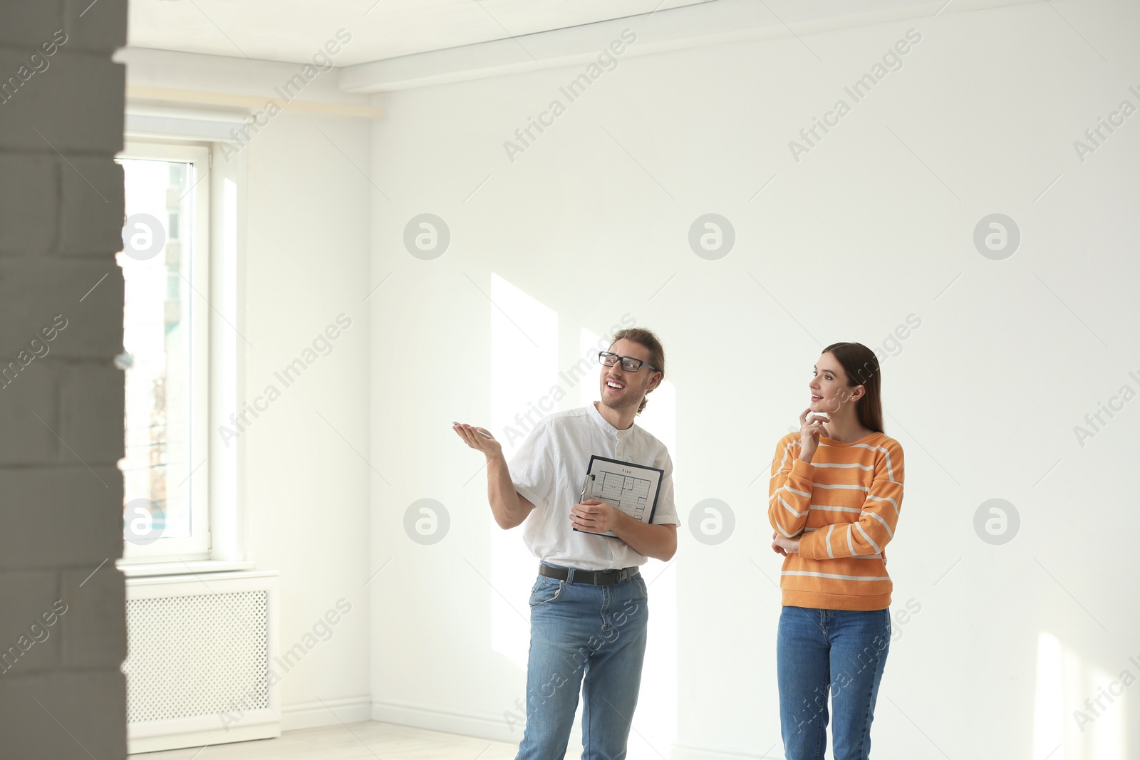 Photo of Professional interior designer consulting woman in empty apartment