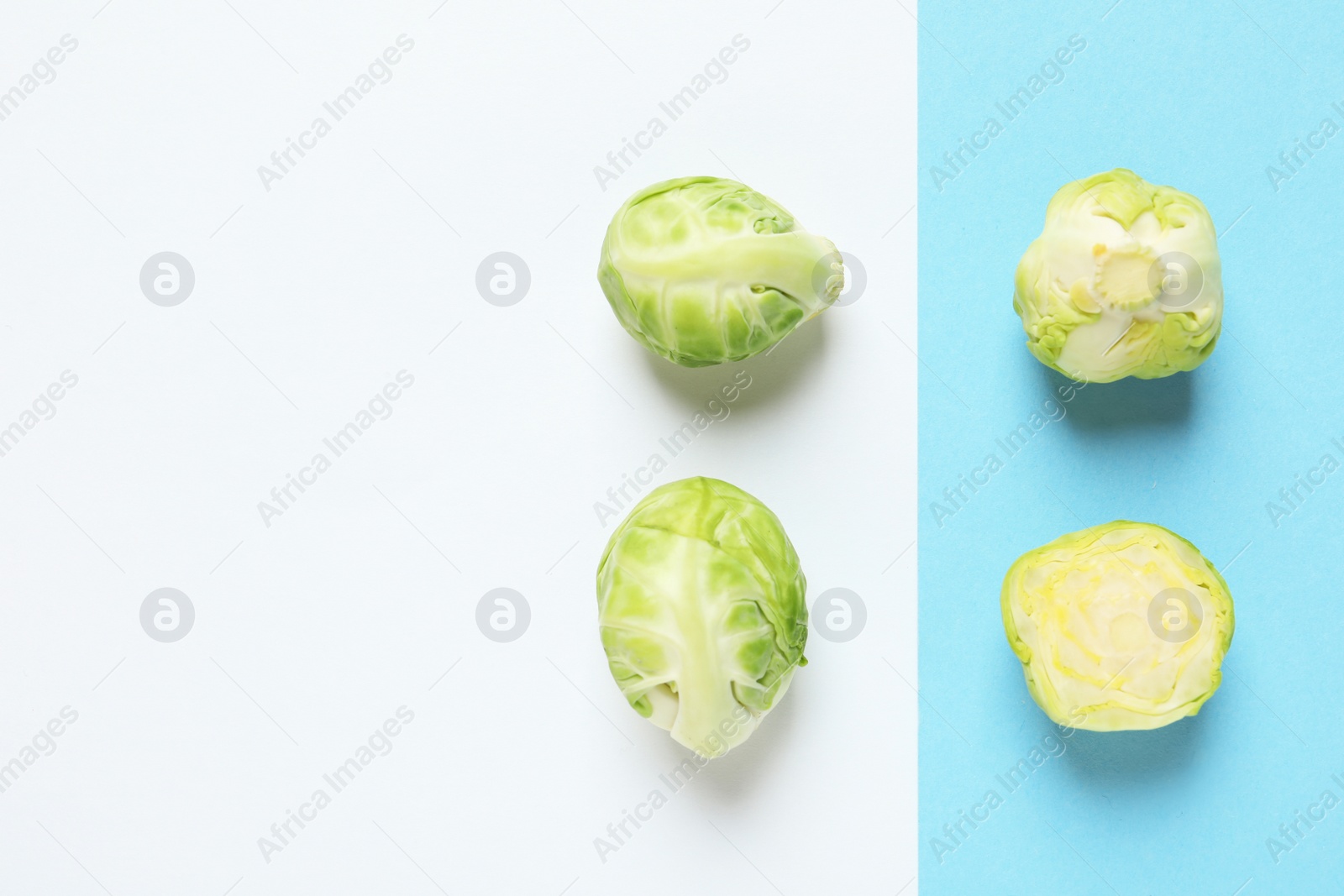 Photo of Fresh Brussels sprouts on color background, flat lay. Space for text