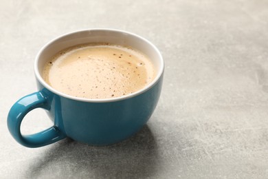 Cup of aromatic coffee on light grey table, closeup. Space for text