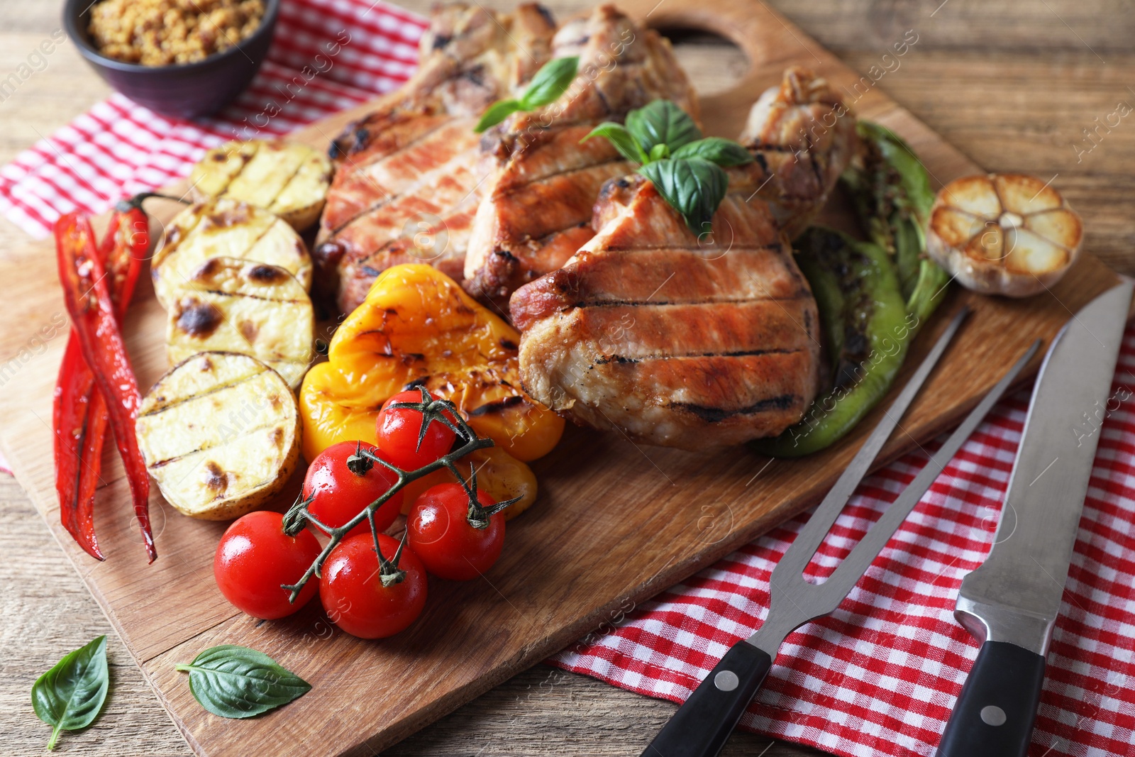 Photo of Delicious grilled meat and vegetables served on wooden table, closeup