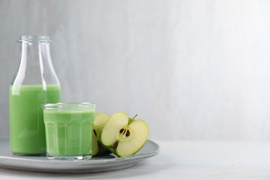 Photo of Tasty fresh apple smoothie on white wooden table, space for text