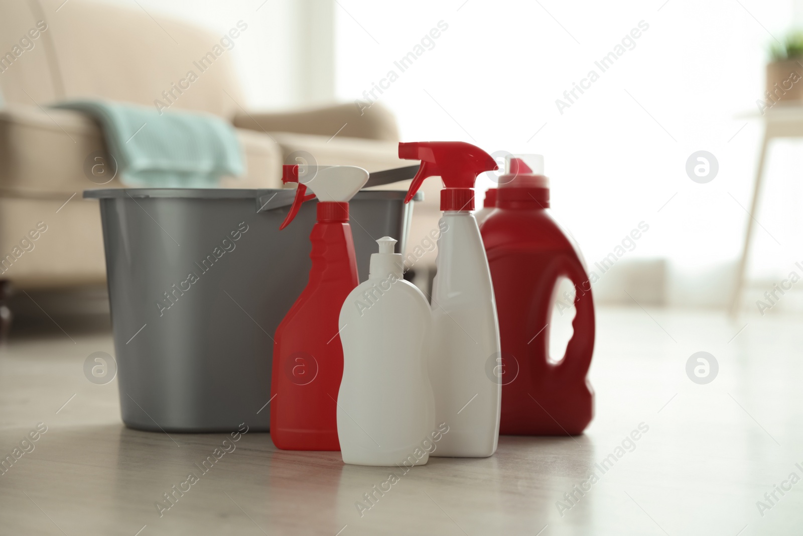 Photo of Bucket and different cleaning supplies on floor indoors