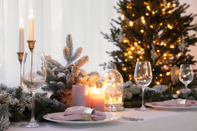 Beautiful festive place setting with Christmas decor on table indoors