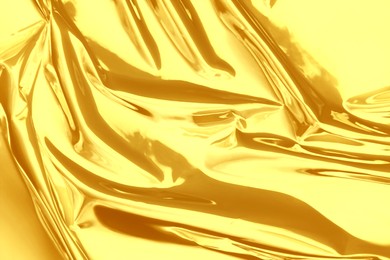 Image of Shiny crumpled golden foil as background, closeup