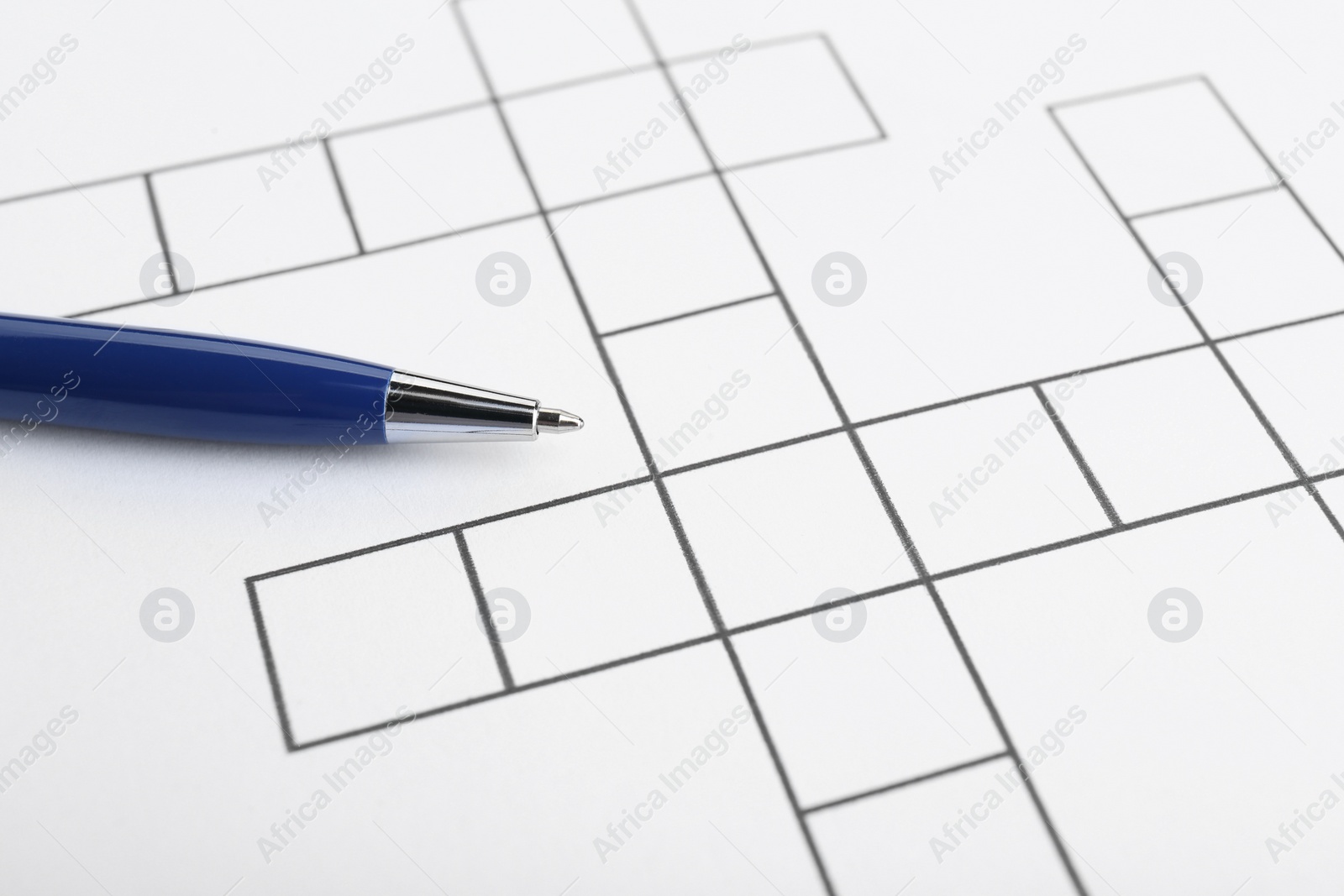 Photo of Pen on blank crossword, closeup. Space for text