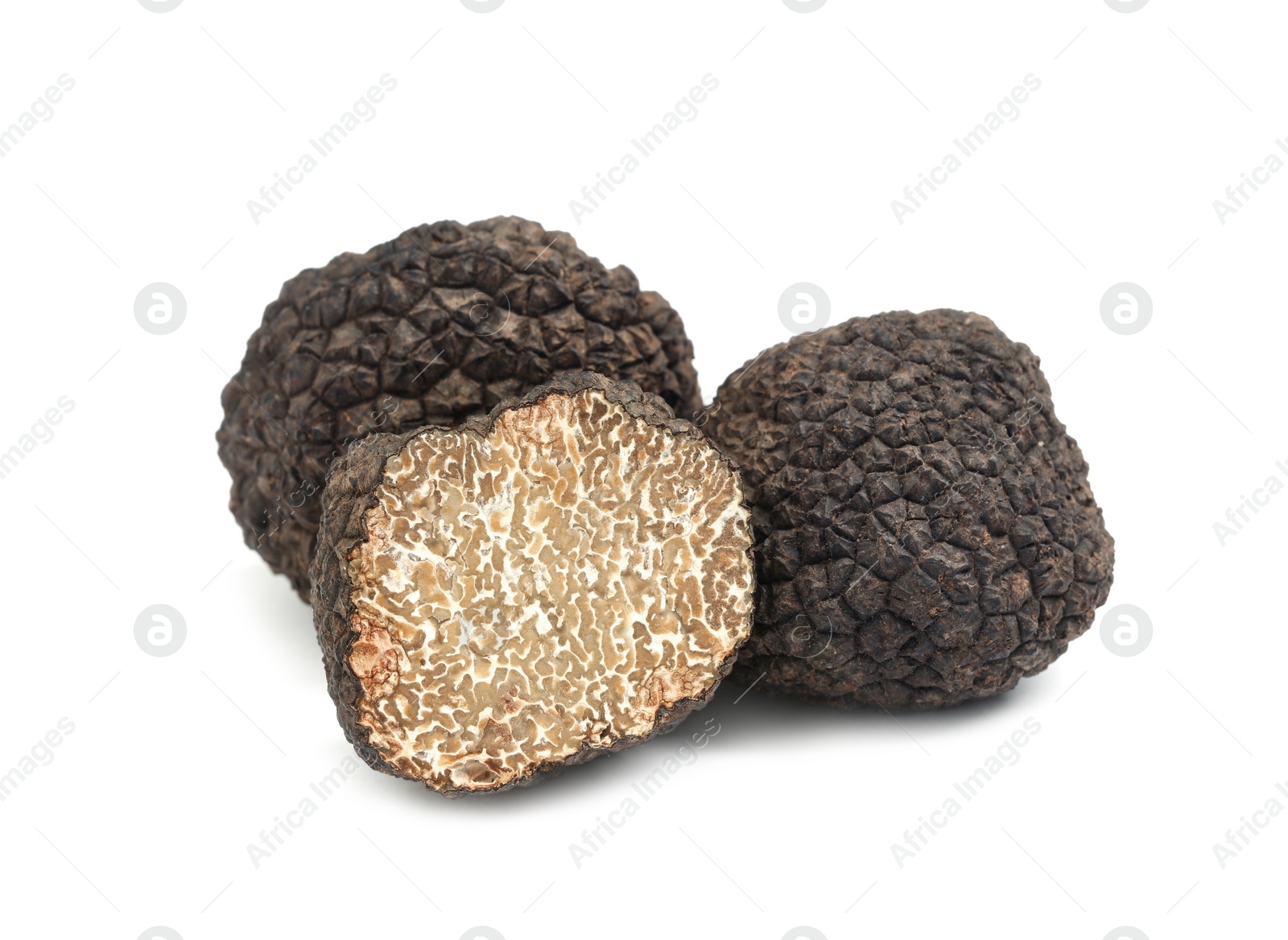 Photo of Cut and whole black truffles isolated on white