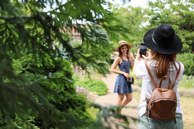 Photo of Woman taking picture of her friend in park