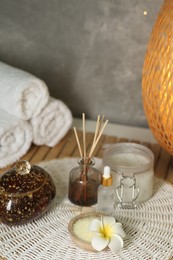 Composition with different spa products and plumeria flower on table