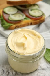 Jar of delicious mayonnaise on table, closeup